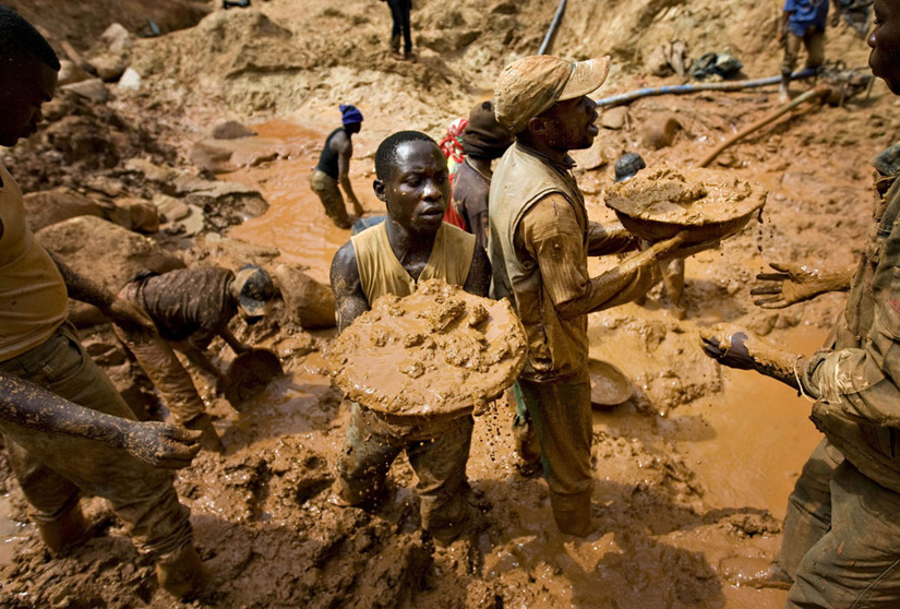 Gold miners form a human chain while digging an open pit at the Chudja mine in the Kilomoto concession near the village of Kobu, 100 km (62 miles) from Bunia in north-eastern Congo, February 23, 2009. Civil conflict in Congo has been driven for more than a decade by the violent struggle for control over the country's vast natural resources, including gold, diamonds and timber, most of which is exploited using hard manual labour. REUTERS/Finbarr O'Reilly (DEMOCRATIC REPUBLIC OF CONGO)